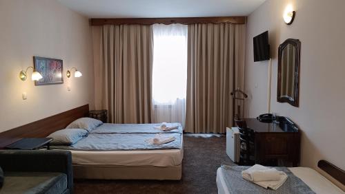 a hotel room with two beds and a window at Hotel St. George Pobedonosets in Bansko