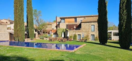 a house with a swimming pool in a yard with trees at Arcs De Monells - Adults Only in Monells