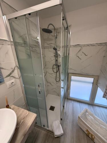 une salle de bain avec une douche avec une porte vitrée dans l'établissement L'Angolo della Piazza, à Caltagirone