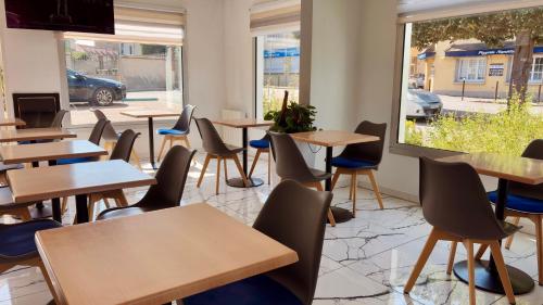 a classroom with tables and chairs and a window at Kyriad Direct Arpajon in Arpajon