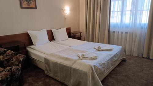 a hotel room with a bed with slippers on it at Hotel St. George Pobedonosets in Bansko