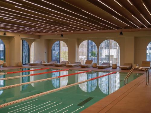 a swimming pool with chairs in the water at Happy Studio Cortina de Luxe in Voluntari
