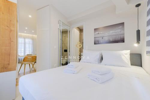 a white bedroom with a white bed and a desk at Zennova #72 Tsinari Comfort & Luxury Suite in Thessaloniki