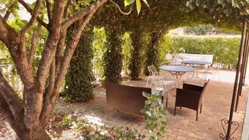 a patio with a table and chairs under an arbor at Kyriad Direct Arpajon in Arpajon