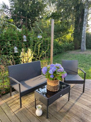 a patio with two benches and a table with purple flowers at Casa Hylle in Löddeköpinge