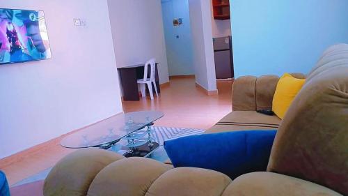 a living room with two couches and a glass table at Sarabi Homes in Mtwapa