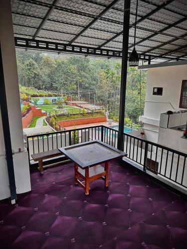 a balcony with a table and a view of a park at Le SAFFRON in Padinjarathara