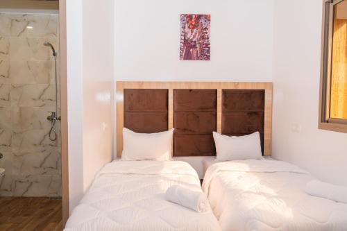 two beds in a room with white walls at Tifawine Stay Guest House Social Stay and Oceanview Rooms in Imsouane