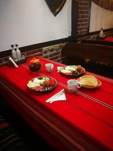 a table with two plates of food on a red table cloth at Hotel St. George Pobedonosets in Bansko