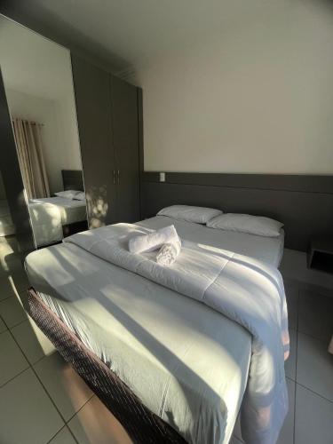 two twin beds in a room with a mirror at Gentil Hotel in Florianópolis