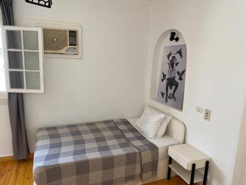 a small bedroom with a bed and a window at Villa Maadi 35 -R 303 -Double Room in Cairo