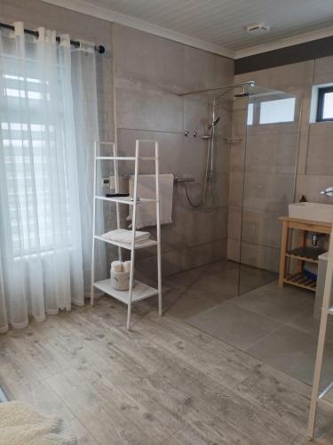 a bathroom with a shower and a white shelf at Heaven Scent in Bettyʼs Bay