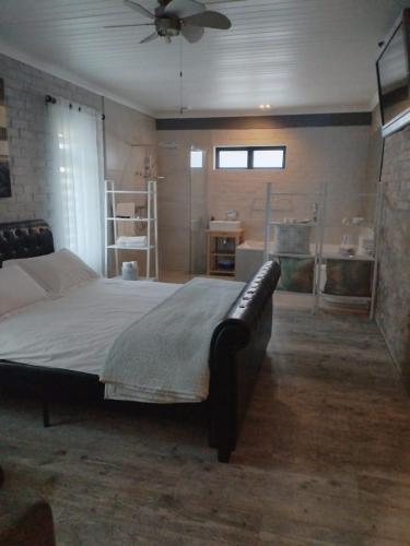 a bedroom with a large bed with a ceiling fan at Heaven Scent in Bettyʼs Bay