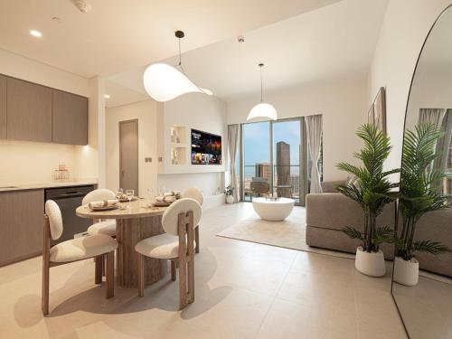 a kitchen and living room with a table and chairs at Grande Signature Residences by Prestige Nest in Dubai