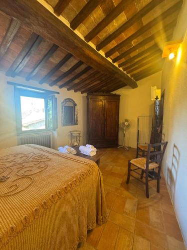 a bedroom with a bed and a chair in a room at Il Borgo Del Lupo Relax Family Apartments in Tuscany with Restaurant & Swimming Pool in Sarteano