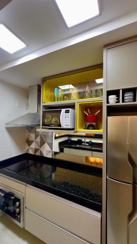 a kitchen with a counter top with a refrigerator at Praia Grande Arraial do Cabo in Arraial do Cabo