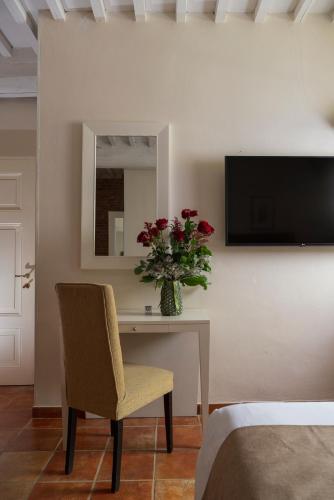a vase of flowers on a table in a room at Castello di Leonina Relais - Adults Only in Siena