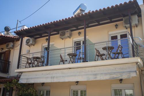 a balcony with chairs and tables on a building at Studios Nopi-Zoi in Skiathos Town