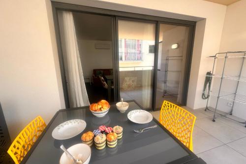 a table with plates and bowls of food on it at Villa Marie 2 Appartement tout confort climatisé 1 chambre proche plage in Le Grau-du-Roi