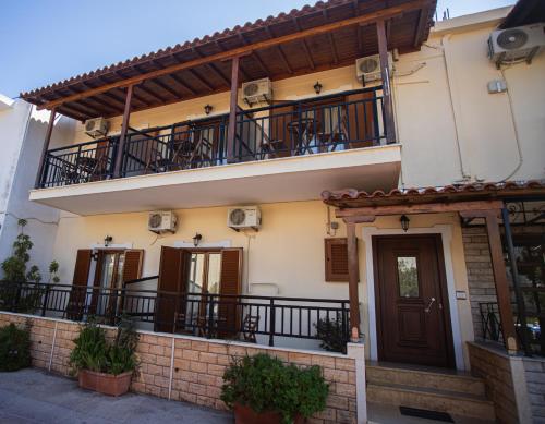 a building with a balcony and a door at Studios Nopi-Zoi in Skiathos Town