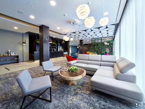 a living room with a couch and a table and chairs at ibis Styles Nowy Targ in Nowy Targ