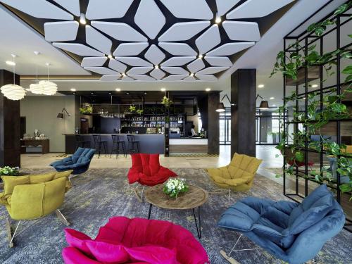 a lobby with colorful chairs and a bar at ibis Styles Nowy Targ in Nowy Targ