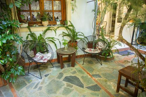a patio with three chairs and a table and potted plants at Studios Nopi-Zoi in Skiathos Town