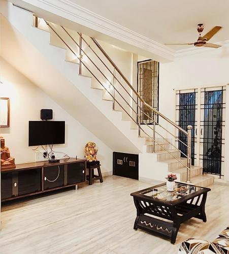 a living room with a staircase and a tv at Indira Residence 5bhk villa in Jāmb