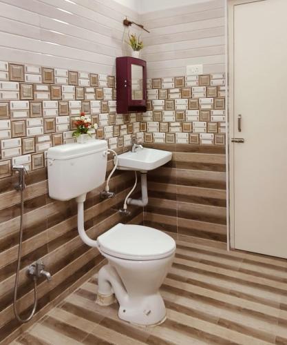 a bathroom with a toilet and a sink at Indira Residence 5bhk villa in Jāmb