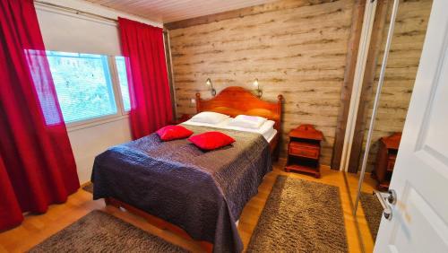 a bedroom with a bed with red pillows at House at the Arctic Circle- next to Santa Claus in Rovaniemi