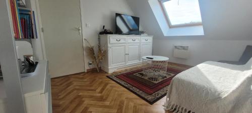 a white room with a bed and a tv on top at Les Châtelliers in Louplande