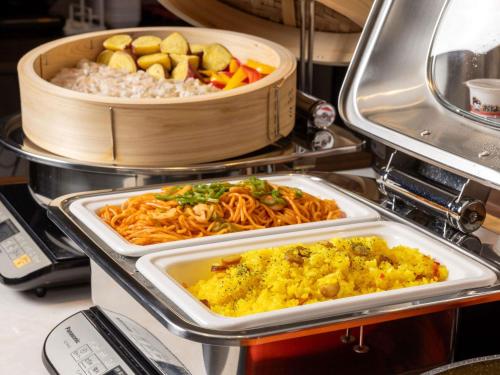 two trays of food on a counter with rice and vegetables at ibis Budget Osaka Umeda in Osaka