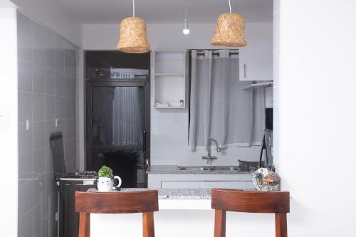 BusiaにあるKayla Suites-2 Bedroom Apartmentの椅子2脚とティーポット付きのテーブルがあるキッチン