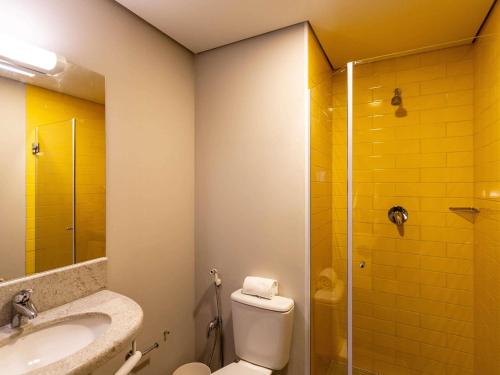 a bathroom with a toilet and a sink and a shower at ibis Palmas Avenida JK in Palmas