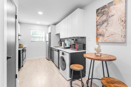 a kitchen with white cabinets and a table in it at Prime SoCo boutique studios with laundry WiFi 7 Min to DT in Austin
