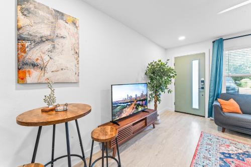 a living room with a tv and a couch at Prime SoCo boutique studios with laundry WiFi 7 Min to DT in Austin