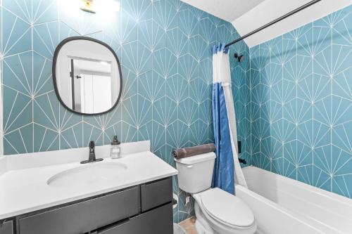 a bathroom with a toilet and a sink and a mirror at Prime SoCo boutique studios with laundry WiFi 7 Min to DT in Austin