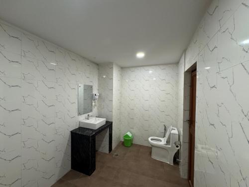 a bathroom with a toilet and a sink and a mirror at Evara Hotel & Apartment in Kathmandu