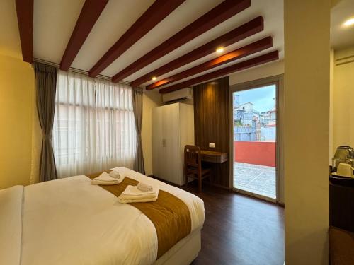 a hotel room with a bed and a large window at Evara Hotel & Apartment in Kathmandu