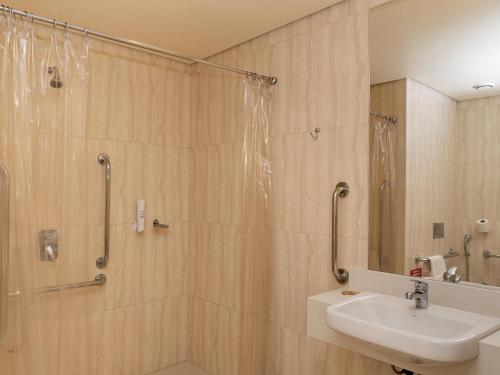 a bathroom with a shower and a sink at ibis Styles Curitiba Aeroporto in São José dos Pinhais