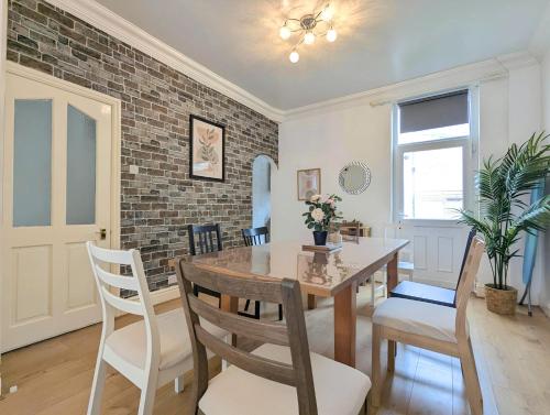 a dining room with a wooden table and chairs at Bright 4br Home Near Anfield & Free Parking in Liverpool
