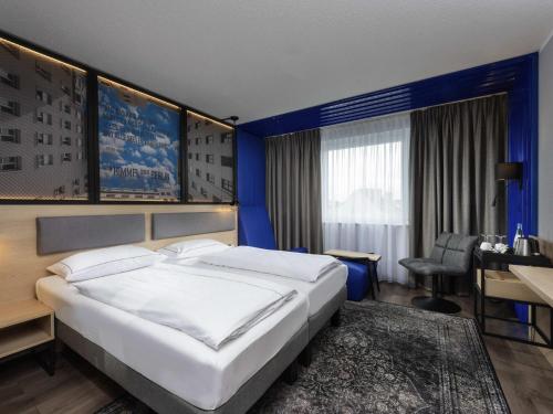 a bedroom with a large bed and a desk at ibis Styles Berlin Treptow in Berlin
