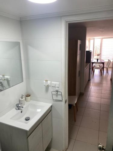 a white bathroom with a sink and a mirror at Vista Abanico in Maitencillo