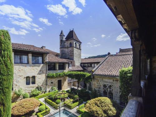 a view of a building with a garden and a tower at Mercure Figeac Viguier du Roy in Figeac