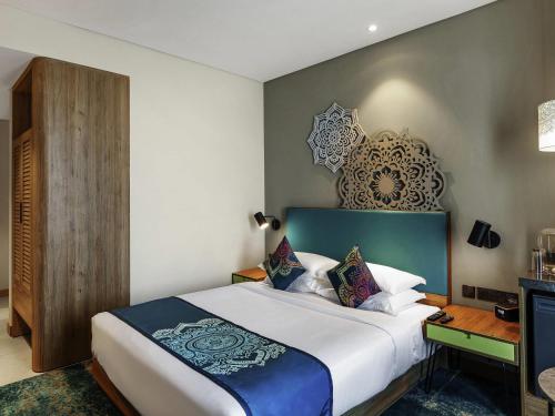 a bedroom with a large bed and a desk at Grand Mercure Ahmedabad GIFT City - An Accor Hotels Brand in Gandhinagar