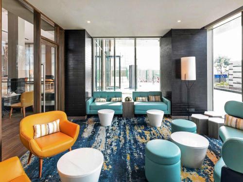a lobby with blue and orange chairs and tables at Grand Mercure Ahmedabad GIFT City - An Accor Hotels Brand in Gandhinagar