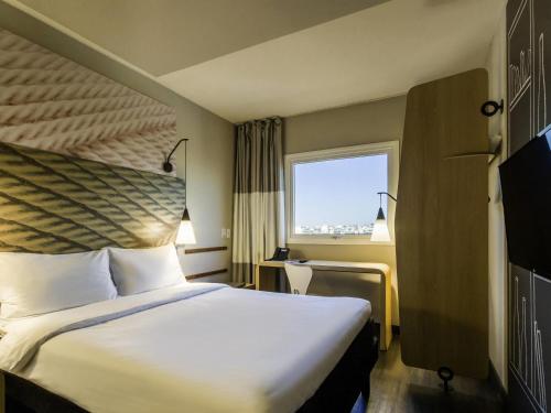a hotel room with a bed and a window at Ibis Americana in Americana