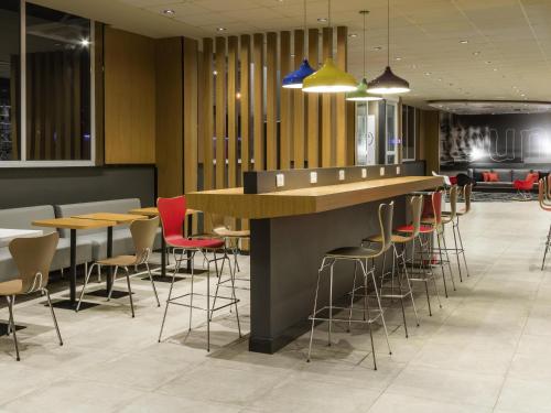 a bar in a restaurant with chairs and tables at Ibis Americana in Americana
