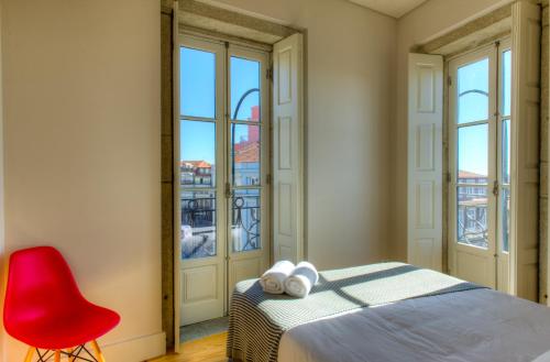 1 dormitorio con 1 cama y 1 silla roja en Porto Cinema Apartments, en Oporto