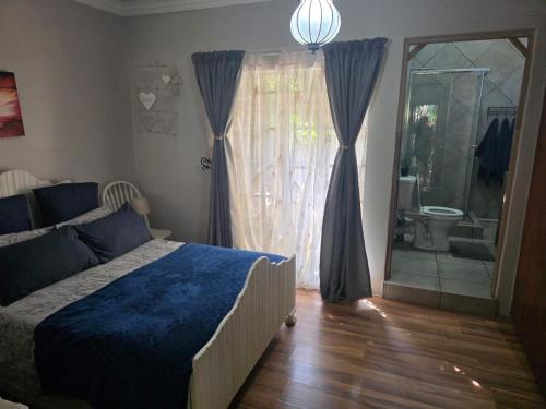 een slaapkamer met een bed en een raam met een badkamer bij The Pot in Pretoria